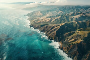 Aerial view of rugged coastal mountains meeting turquoise ocean waters