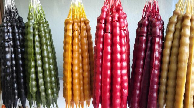 Hanging rows of colorful Churchkhela snacks. Close-up video of Georgian traditional sweets made of nuts and grape juice. Ethnic food concept for design and print.