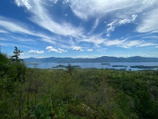 wispy clouds over lake and mountains