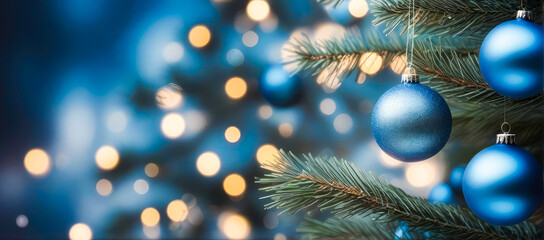 Blue Christmas ornaments in vibrant blue and silver, hanging  tree branch with warm bokeh lights , glowing softly in the evening light.