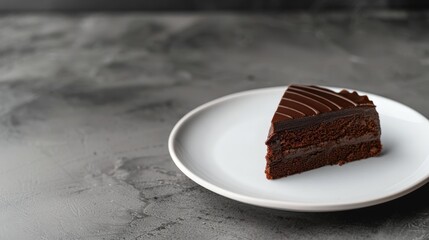 Elegant Slice of Rich Chocolate Cake on White Plate: A Stunning Contrast Against Grey Stone