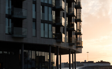 Glowing sunset highlights on glass walls of condo in Tjuvholmen
