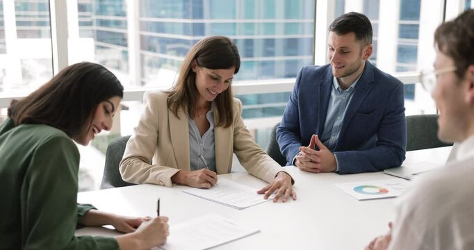 Business parties gathered in conference room, discussing contract details, signing legal agreement documents, shaking hands, express mutual respect, thanking for cooperation and successful partnership