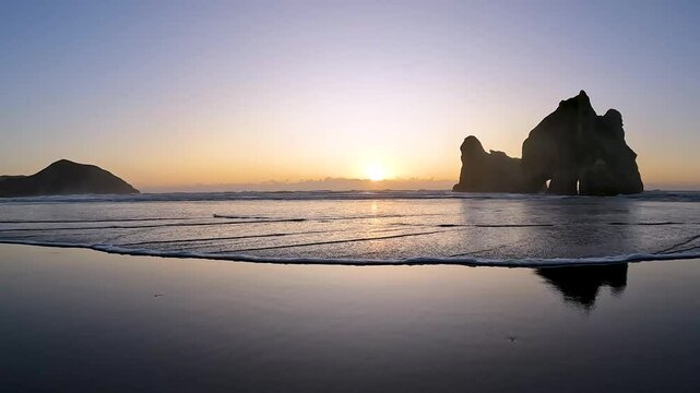 Wharariki Beach at Golden Sunset: A Scenic View of the Tasman Sea and Cape Farewell Coastline, New Zealand
