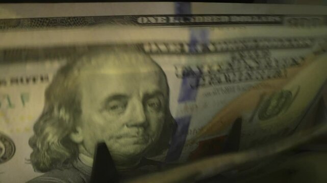 Close up cash counting machine counting money. Banknotes of 100 dollar bills. Money count machine, investment banking, cash transaction concept. Finance, currency and crisis recession.