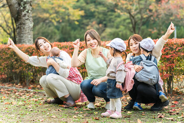 秋の公園を散歩・遠足する保育士の女性と園児（保育園・幼稚園保母・子供・幼児）
