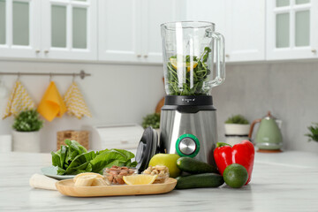 Modern blender with ingredients for smoothie on white marble table in kitchen