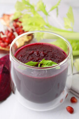 Fresh beetroot smoothie with mint in glass on white table, closeup
