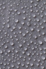 Water drops on gray background, top view