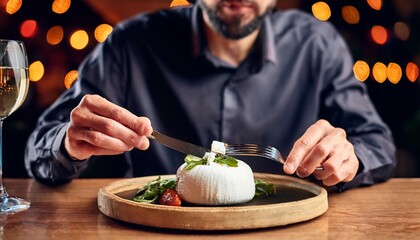 Fototapeta premium Faceless man eat Provolone in restaurant with bokeh background. Italian Food.
