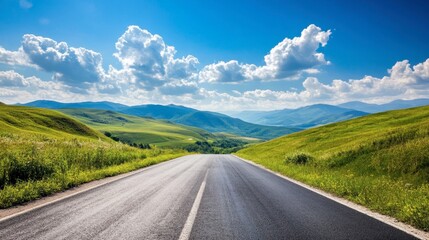 A scenic asphalt road through green hills and mountains, with a clear sky and puffy white clouds on a sunny day.