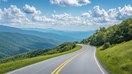 Fototapeta premium A scenic asphalt road weaving through green mountains, with a bright sky and scattered clouds on a sunny afternoon.