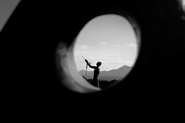 Native american statue praying to the sky with mountains 
