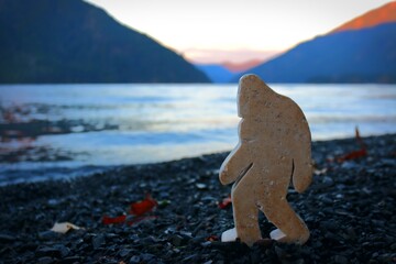 Stone bigfoot on lakeshore at sunset in the pnw 
