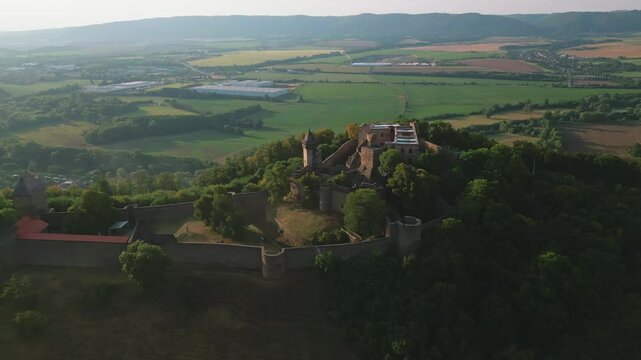 Aerial view of a historic Helfstyn castle with surrounding walls amidst a vast landscape