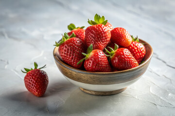 Fresh strawberries arranged artfully in ceramic bowl on textured surface create vibrant and inviting display. rich red color and natural shine evoke sense of freshness and delight