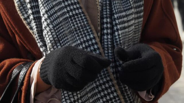 woman hands put on warm gloves on a winter cold day,