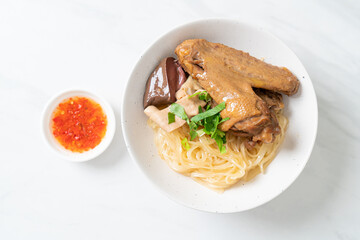 dried noodles with braised duck in white bowl