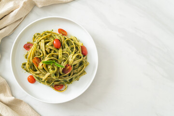 fettuccine spaghetti pasta with pesto sauce and tomatoes