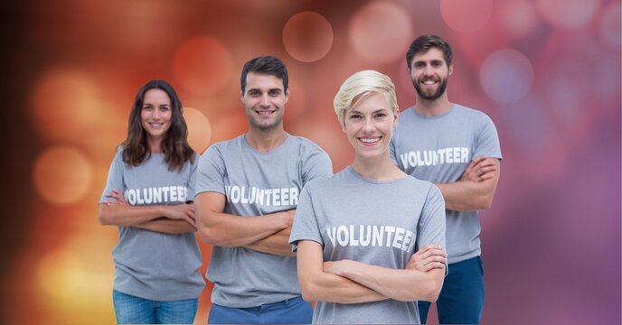 Portrait of diverse volunteers arms crossed against spots of light in background