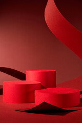 Elegant design features three red cylindrical podiums on a red background, ideal for presenting...