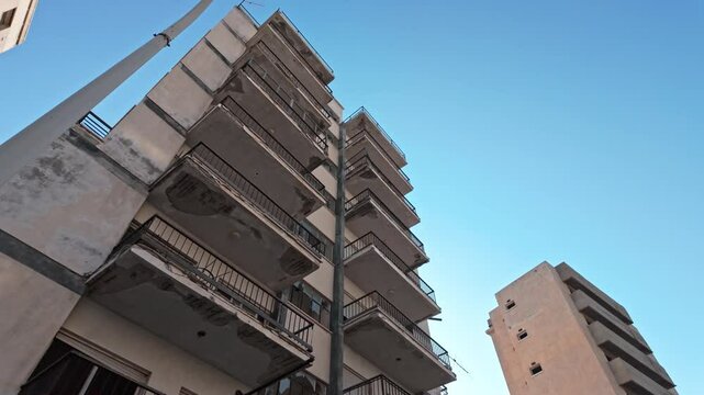 Tall abandoned apartment buildings in Varosha, Cyprus, with a clear blue sky in the background