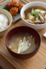 木のテーブルの上に置かれた味噌汁と日本の健康的な家庭料理
