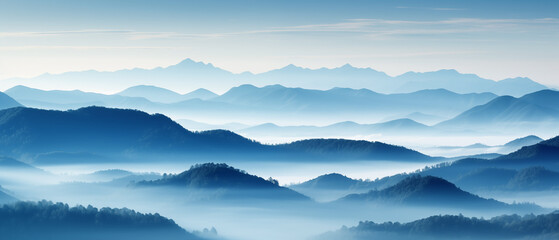 Obraz premium Majestic misty mountains at dawn with soft blue tones and layered peaks