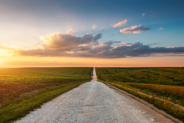 Country road passes through agricultural land and cultivated fields.