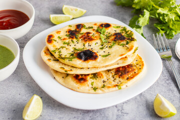 Naan is a soft, fluffy, and slightly chewy Indian flatbread, traditionally baked in a tandoor, often served with curries.
