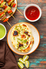 Naan is a soft, fluffy, and slightly chewy Indian flatbread, traditionally baked in a tandoor, often served with curries.
