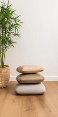 A tranquil corner featuring stacked neutral cushions and a potted bamboo plant indoors
