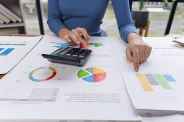 Close up of businesswoman uses a calculator to calculate business principles. Accounting statistical concepts at the office starting a financial business, calculating accounting online marketing.
