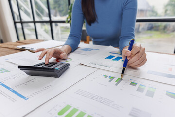 Business financing accounting banking concept. Business woman hand doing finances and calculate on desk about cost at home office. Woman working on desk with using calculator, finance accounting.
