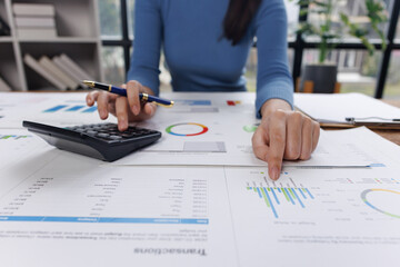 Business financing accounting banking concept. Business woman hand doing finances and calculate on desk about cost at home office. Woman working on desk with using calculator, finance accounting.
