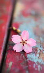 27. A delicate pink sakura branch resting on a weathered wooden table, with a vibrant flower background that enhances the cheerful atmosphere of the spring season
