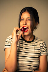 Young Indian woman eating a fruit