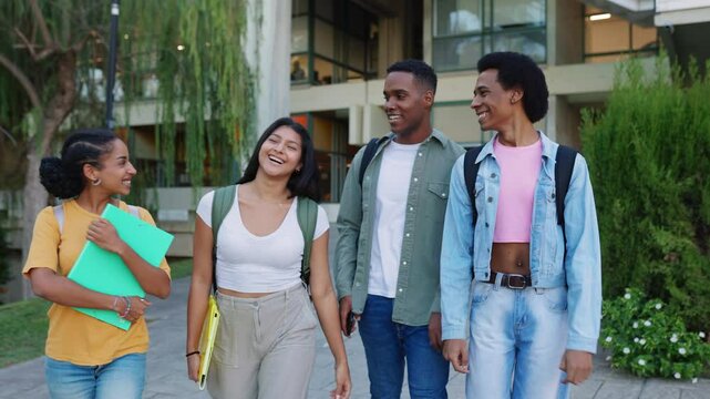 Small group of young Latin American student friends laughing while leaving campus college after classes. Education lifestyle concept.
