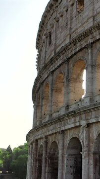 Il colosseo illuminato dal sole alle prime luci dell'alba. Roma, Italia.
Vista erea del colosseo con i raggi del sole che attraversano gli archi. Video Verticale. 
