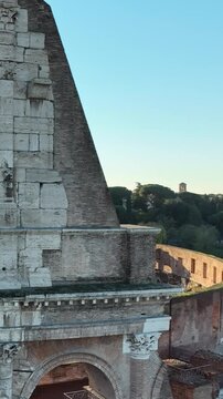 Il colosseo illuminato dal sole alle prime luci dell'alba. Roma, Italia.
Vista erea del colosseo con i raggi del sole che attraversano gli archi. Video Verticale. 
