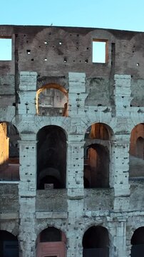 Il colosseo illuminato dal sole alle prime luci dell'alba. Roma, Italia.
Vista erea del colosseo con i raggi del sole che attraversano gli archi. Video Verticale. 
