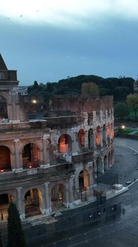 Il colosseo (anfiteatro flavio) al crepuscolo. Roma, Italia.
Vista erea in primo piano della facciata del colosseo, con le luci che illuminano gli archi. Video Verticale. 