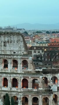 Il colosseo (anfiteatro flavio) al crepuscolo. Roma, Italia.
Vista erea in primo piano della facciata del colosseo, con le luci che illuminano gli archi. Video Verticale. 