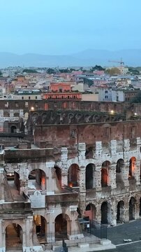 Il colosseo (anfiteatro flavio) al crepuscolo. Roma, Italia.
Vista erea in primo piano della facciata del colosseo, con le luci che illuminano gli archi. Video Verticale. 