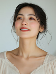 Fototapeta premium close up portrait of Asian woman with her chin lifted, showcasing serene expression and natural beauty. Her soft features and gentle smile convey sense of calm and confidence