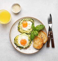 fried egg in zucchini noodle nest with sesame, healthy breakfast, top view