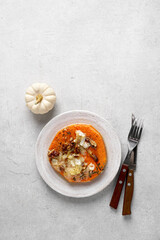 Baked pumpkin slices with spices and cubes of cheese and walnuts. Pumpkin dishes. Copy space
