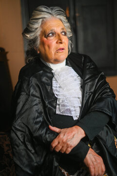 Senior female judge wearing judicial robe and jabot contemplating case