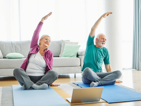  senior stretching exercise woman training lifestyle sport fitness home healthy man couple together pilates gym exercising fit laptop yoga meditation online class instruction