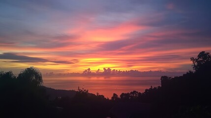 Fototapeta premium A stunning sunset view from a cliffside viewpoint in Satun, with vibrant colors painting the sky.